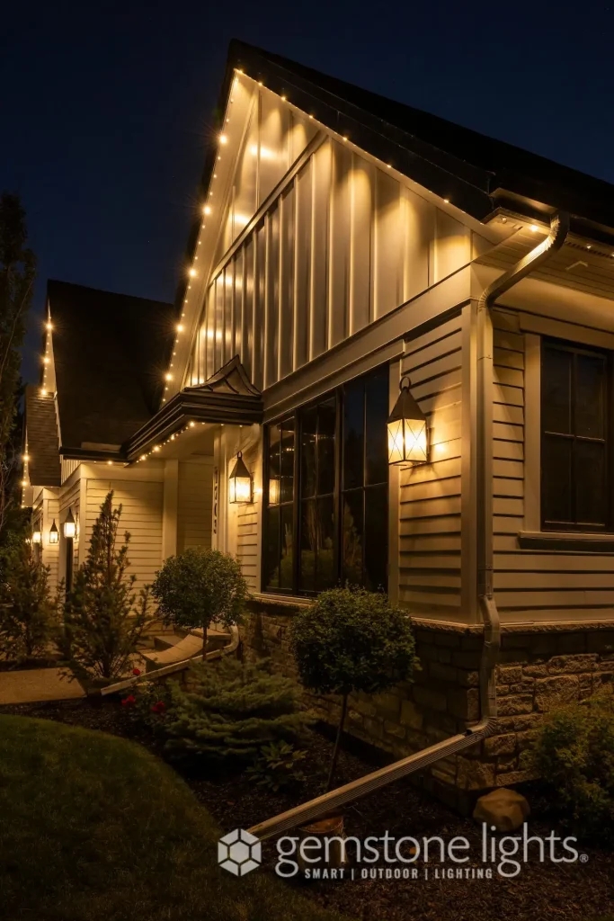 Warm, decorative lights illuminate a charming home at night, highlighting its architectural features