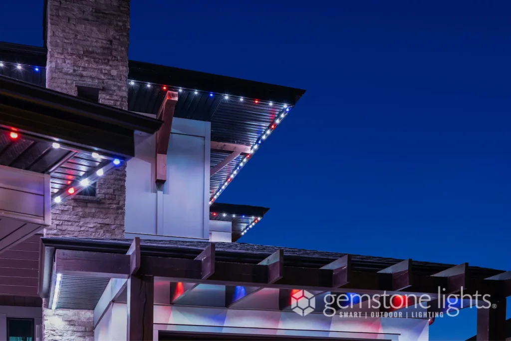 A modern house is adorned with colorful lights against a twilight sky