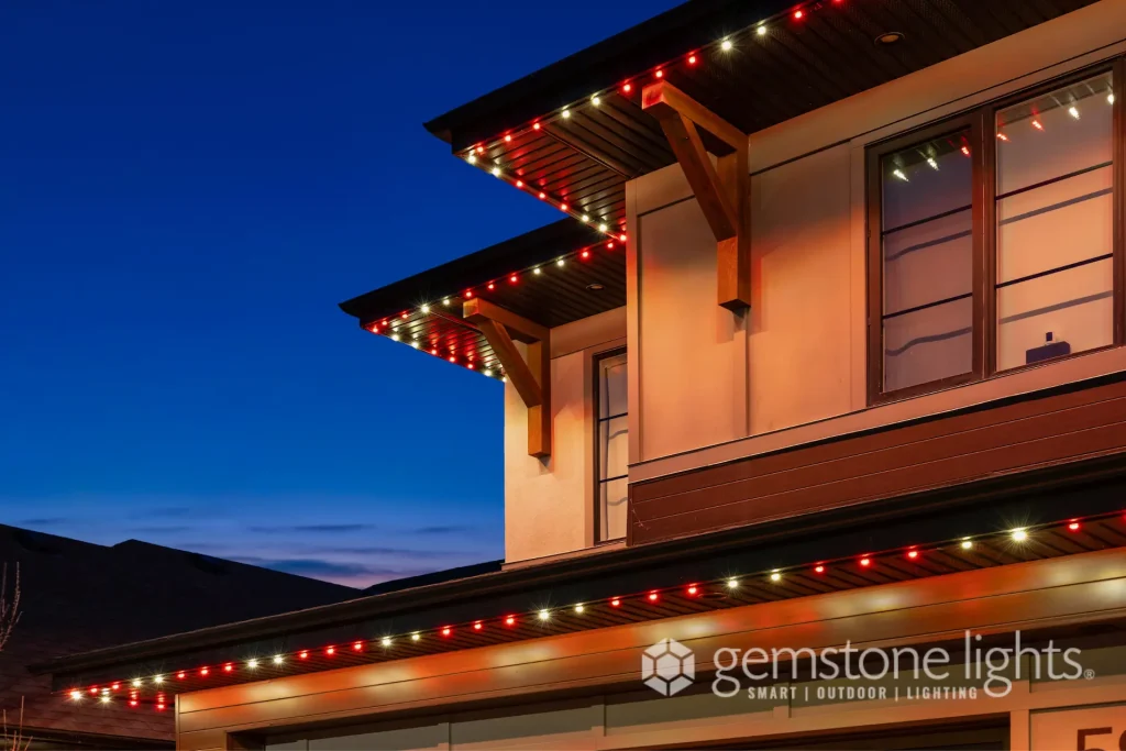 Colorful holiday lights adorn the roofline against a twilight sky