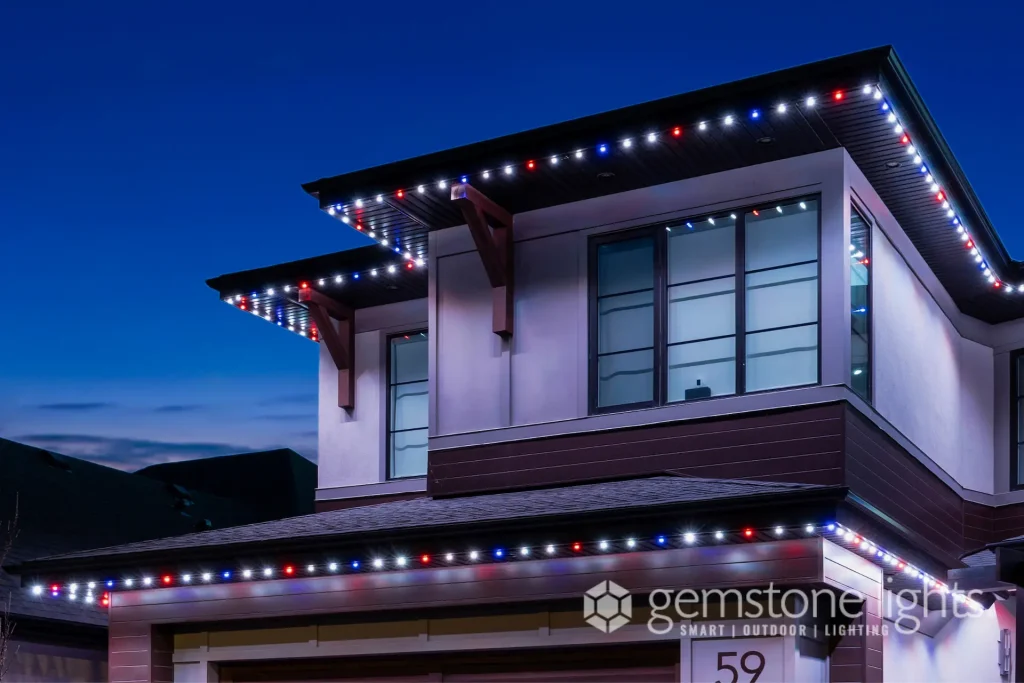 Colorful lights outline the eaves of a modern house at dusk