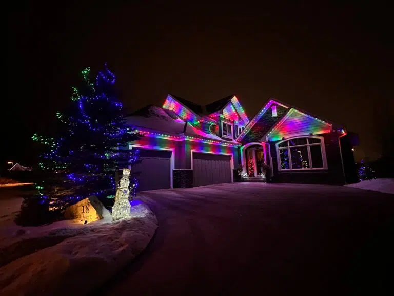 A beautifully lit house adorned with colorful Christmas lights shines in the dark