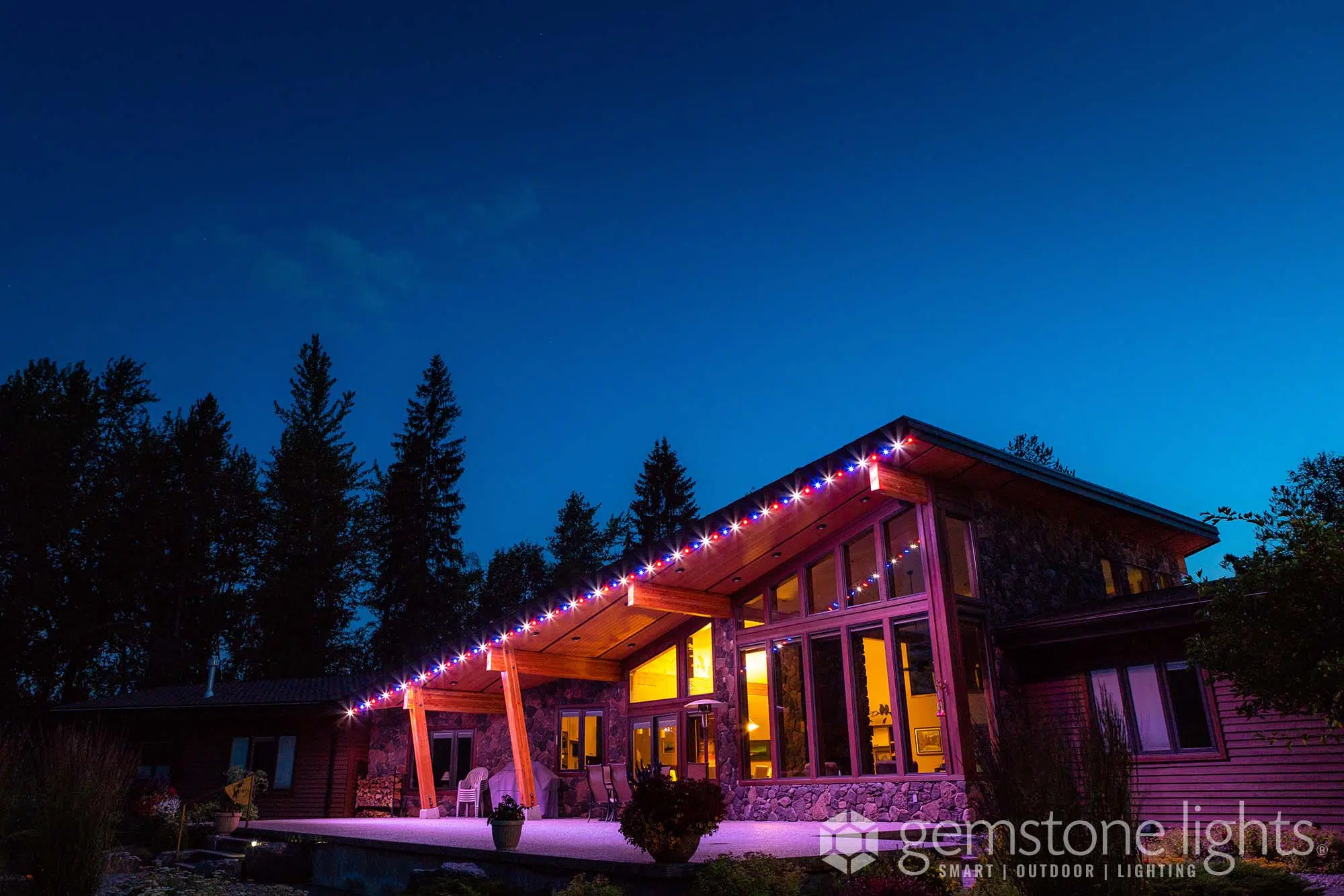 A beautifully lit wooden structure glows warmly against a darkening sky