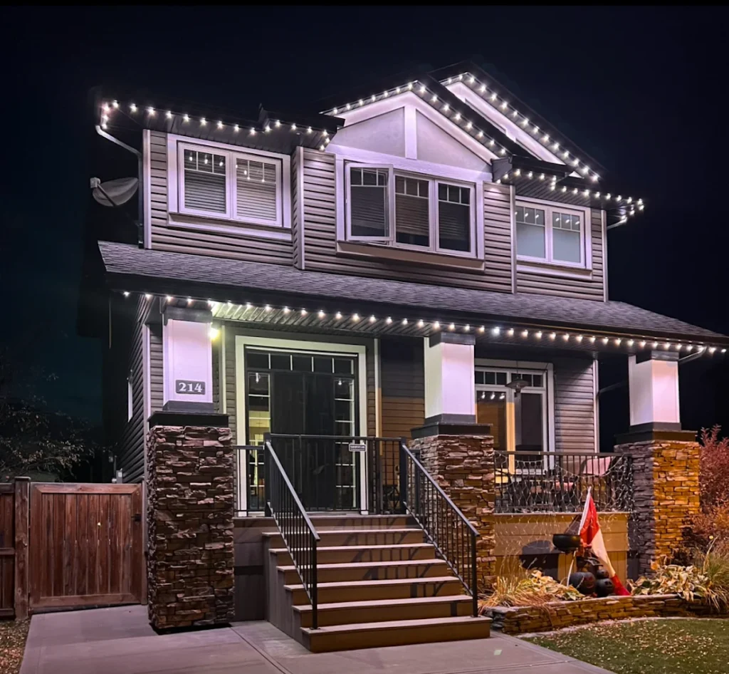 A beautifully lit two-story house displays festive illumination against a night sky